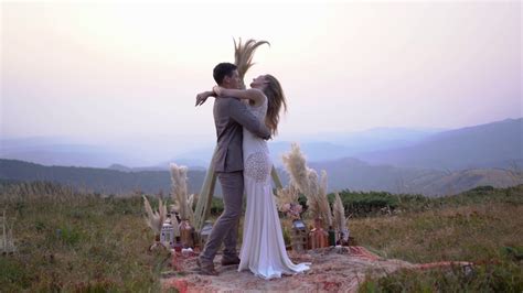 幸福的新婚夫妇站在日落的山上拥抱视频素材_ID:VCG42N1386331392-VCG.COM