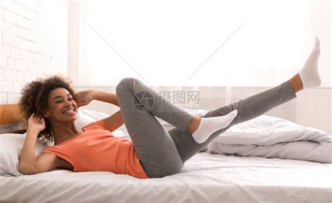 快乐的女孩早上在床上锻炼做仰卧起坐高清图片下载-正版图片505779721-摄图网