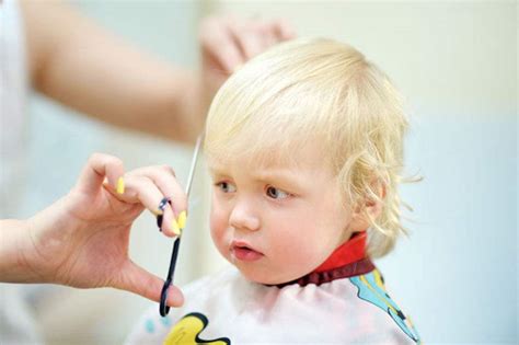 美发师特写镜头的孩子孩子在理发店的第一次理发婴儿高清图片下载-正版图片502688988-摄图网