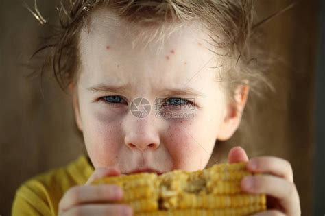 玉米地里美丽快乐的微笑小男孩用手抚摸植物高清摄影大图-千库网