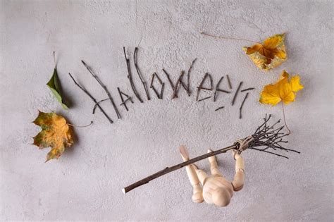 Premium Photo | A wooden man sweeps away the word halloween made of ...