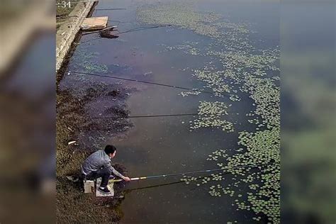 几位男子河边钓鱼，没想到边上男子上大鱼，男子直接掏出手机先照相再钓鱼_男子_大鱼_手机