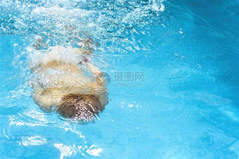 年轻的天主教红发男孩在蓝色水池里游泳流高清图片下载-正版图片502880928-摄图网