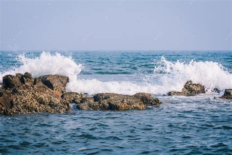 青岛清晨浪花礁石拍打摄影图配图高清摄影大图-千库网