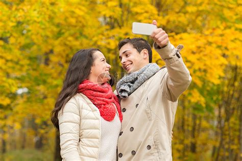 爱,关系,家庭人的微笑的夫妇拥抱自拍秋天的公园高清图片下载-正版图片300833483-摄图网