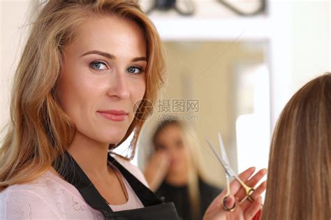 美丽的金发女理发师手里拿着剪刀高清图片下载-正版图片502593878-摄图网