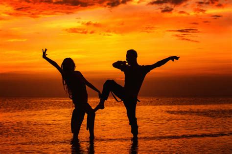 在海滩上摆姿势的年轻夫妻剪影图片-黄昏时站在海滩上摆姿势的年轻夫妻剪影素材-高清图片-摄影照片-寻图免费打包下载